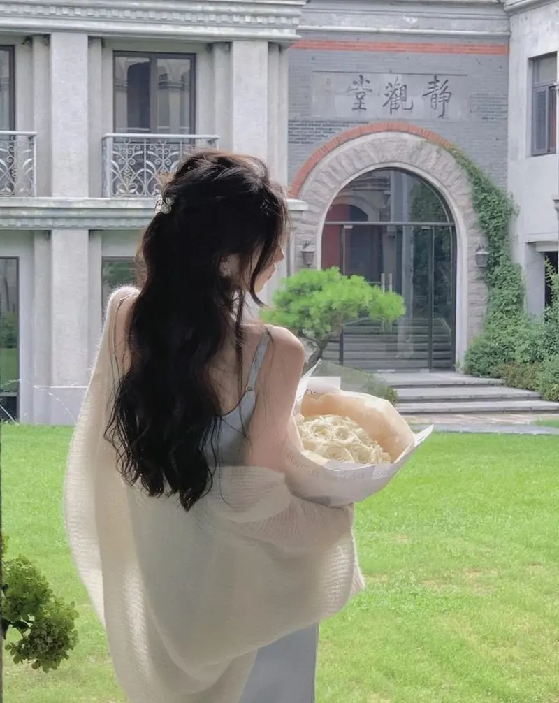 Cô gái tóc dài buồn quay lưng với bó hoa trắng Cô gái tóc dài buồn quay lưng với bó hoa trắng