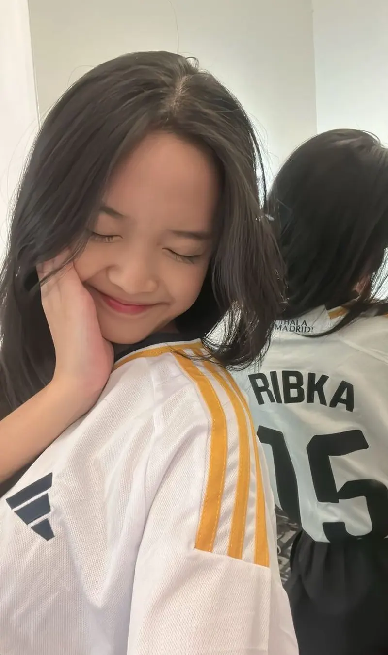 Nụ cười đáng yêu của gái xinh diện áo bóng đá màu trắng với số áo nổi bật phía sau 